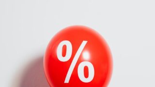 person holding a red balloon with percentage symbol
